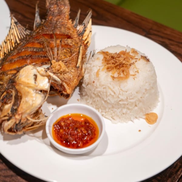 Crispy fried whole fish, white rice topped with fried shallots, and a side of red chili sauce.